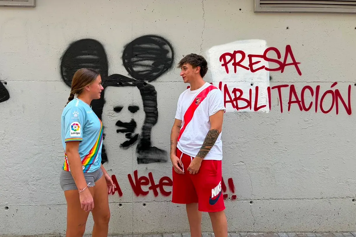 Hugo y Nahia delante de una pintada en el Estadio de Vallecas contra Martín Presa